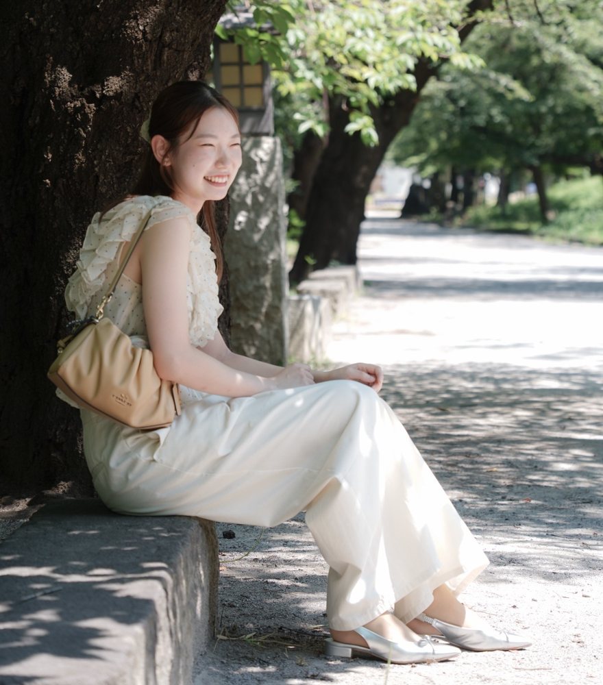 木陰で笑顔を見せる、まほら主宰・講師のさき